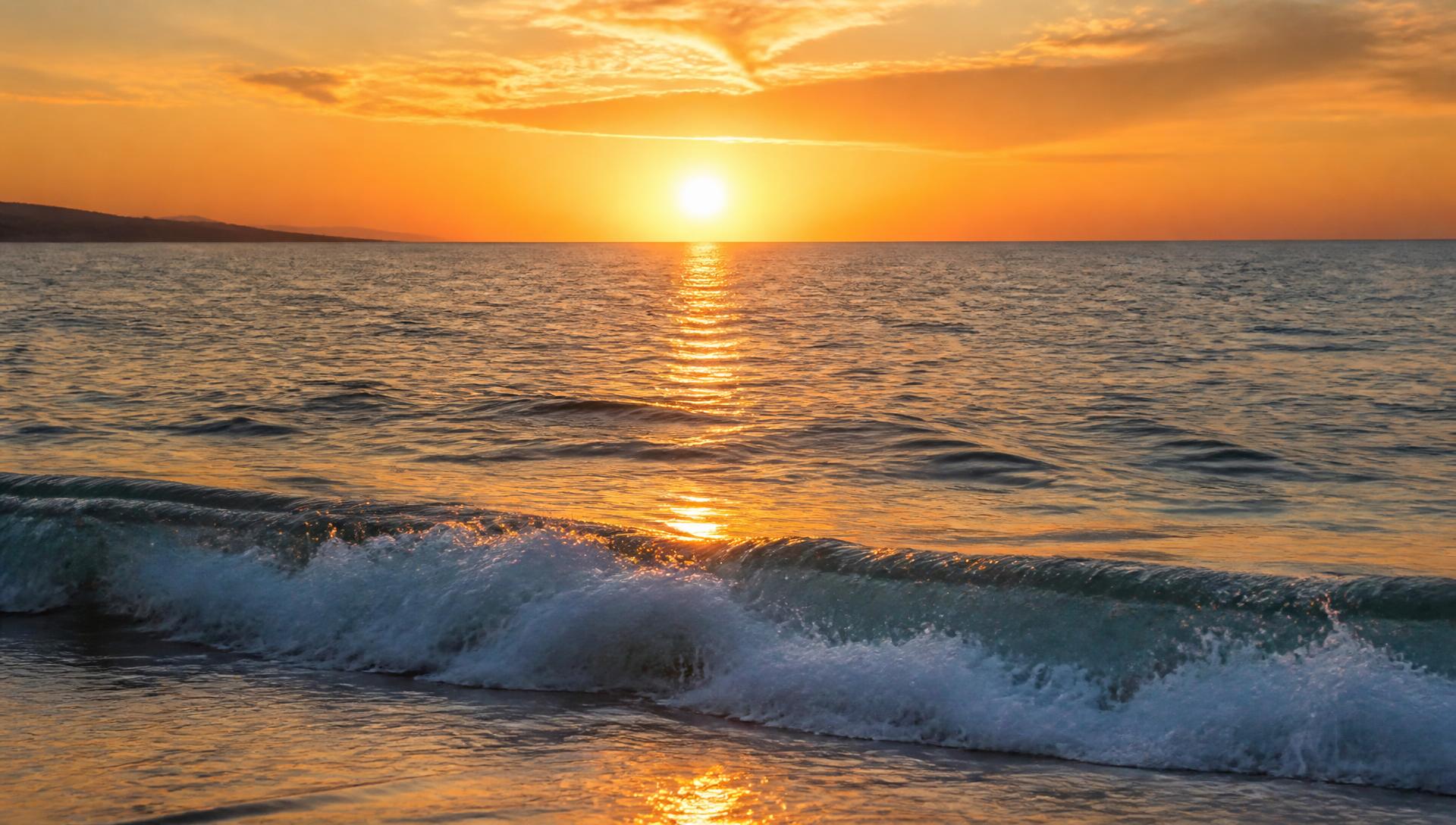 Sunrise over moving ocean water